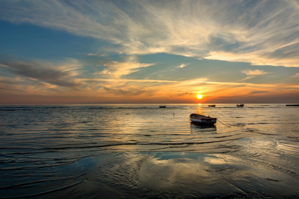 Zachód słońca, morze i łódka