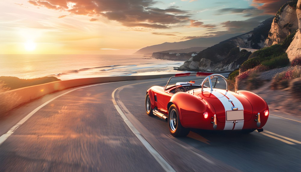 Czerwony klasyczny samochód sportowy na nadmorskiej drodze