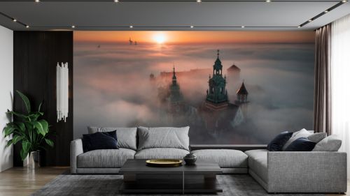 Wawel Castle in Kraków, Poland. Aerial, drone photo of the Royal Castle above the morning fog during the sunrise.