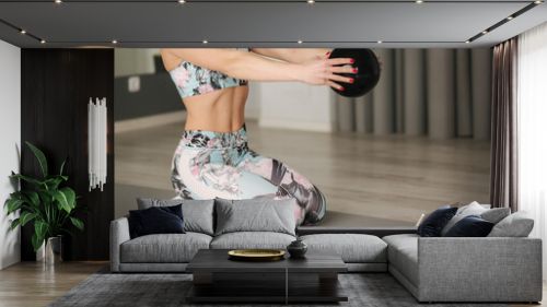Athletic woman in sportswear does exercises at home. Woman look in tablet while diong exercises. Sport and recreation concept. Healthy lifestyle