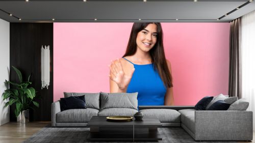 Young Brazilian woman isolated on pink background counting five with fingers