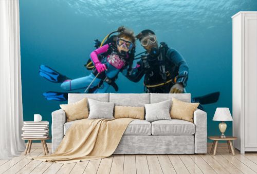 child scuba diver and adult diver go diving