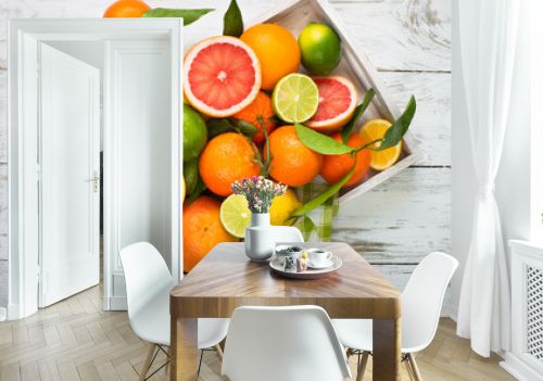 Citrus fruit in wooden tray on white table. Healthy eating and diet.