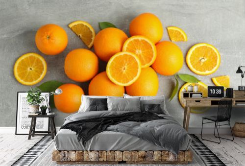 Many ripe oranges and leaves with space for text on grey table, top view