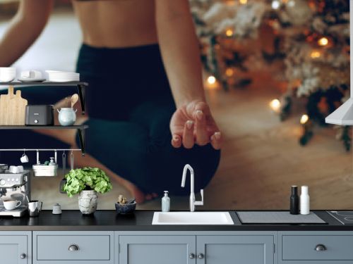 Beautiful woman practices yoga in christmas. 