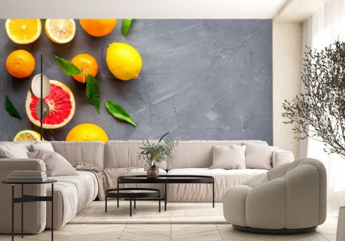 Citrus fruits frame - halfs of lemons, grapefruits, leaves - on grey background top-down copy space