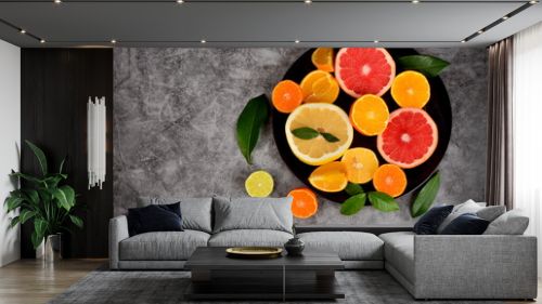 Cut citrus on a plate, Various citrus fruits, Citrus on a concrete background, copy space