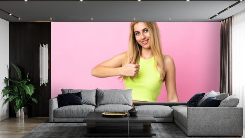 Young Uruguayan blonde woman over isolated pink background giving a thumbs up gesture