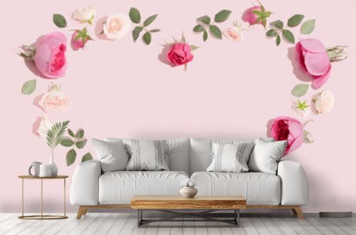 Creative flowers composition. Heart symbol made of pink rose flowers on pastel pink background. Minimal flat lay.