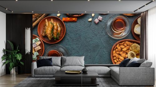 Frame made of traditional Eastern sweets and tea for Ramadan on dark color background
