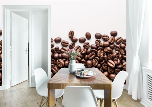 Coffee beans artfully arranged on the white background create a mesmerizing pattern with white copy space