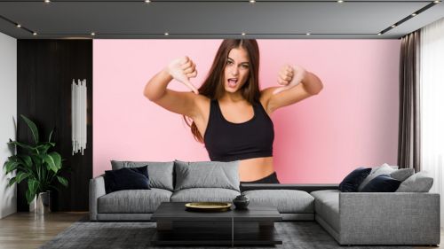 Young caucasian fitness woman doing sport isolated showing thumb down and expressing dislike.
