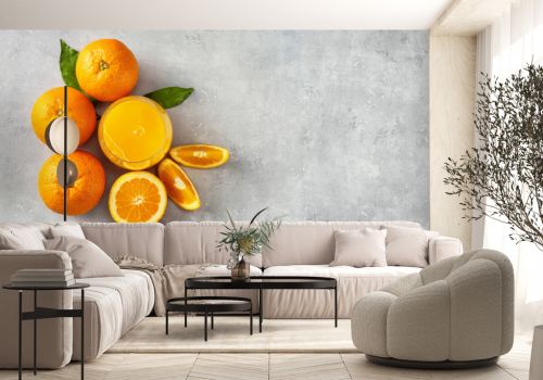 Top view of fresh orange juice, oranges and slices on grey concrete background